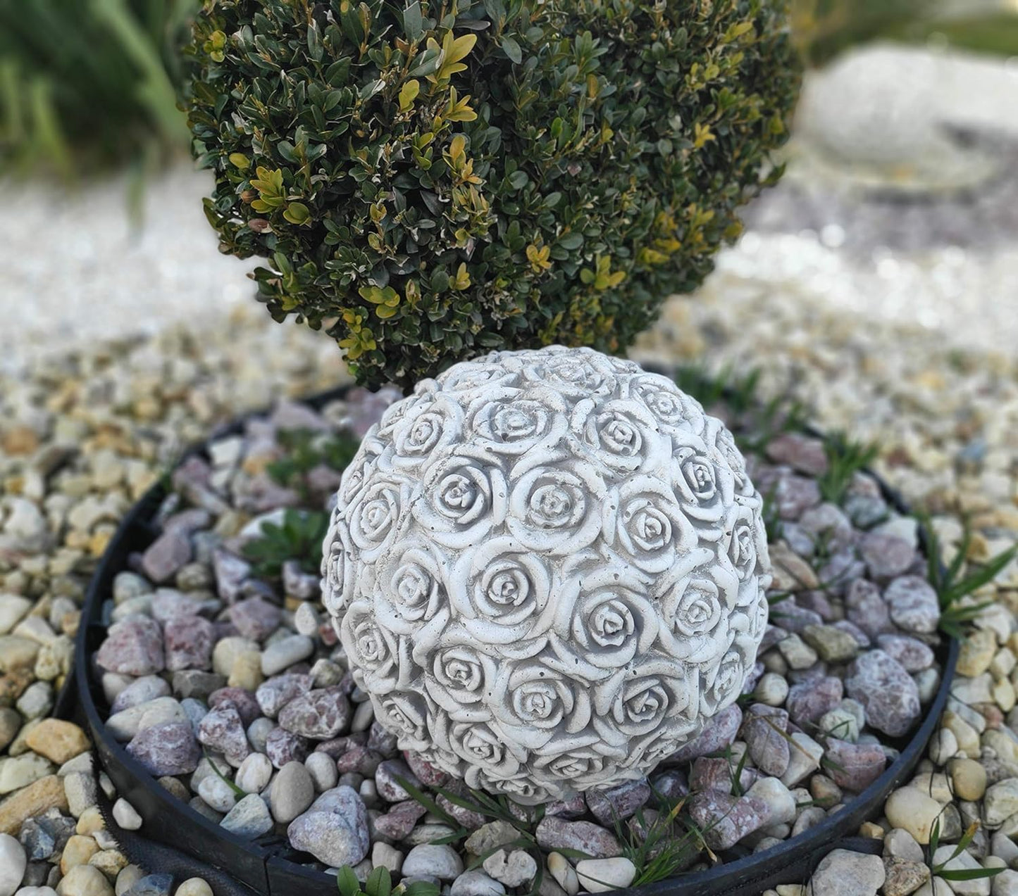 Bola de jardim de concreto coberta de rosas